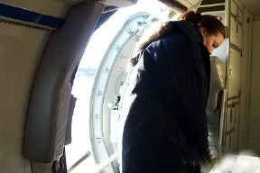 Stewardess in her practical uniform opening the hatch