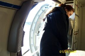 Stewardess in her practical uniform opening the hatch