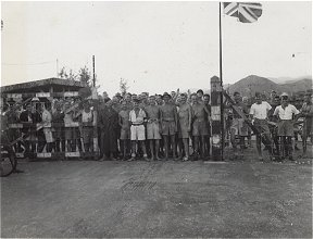 Men at gate of POW camp, Kowloon